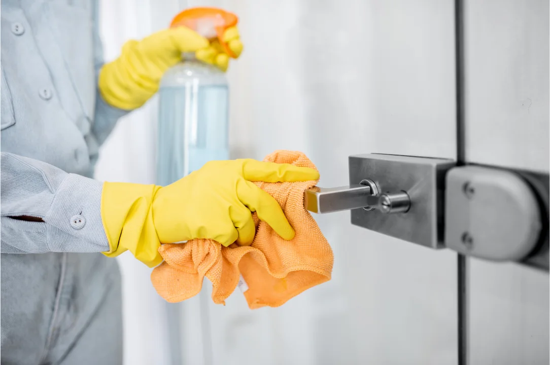 Cleaner wiping a door handle during property cleaning